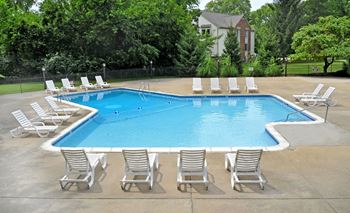 a swimming pool with chaise lounge chairs and trees in the background  at Fox Pointe Apartments, East Moline, 61244
